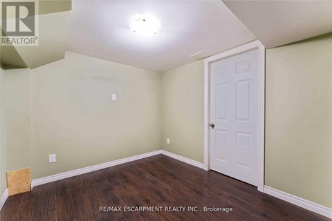 A room with a white door and a wooden floor.
