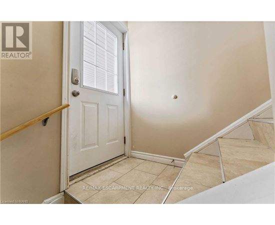 A white door is in a room with a wooden banister.