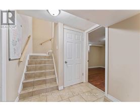A hallway with a staircase leading to the second floor.