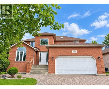 A red brick house with a white garage door and a number 512 on the front.