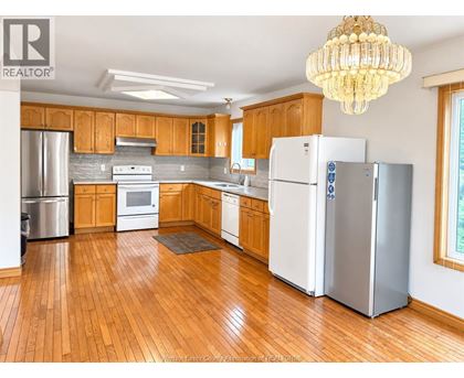 A kitchen with wooden cabinets and a white refrigerator.