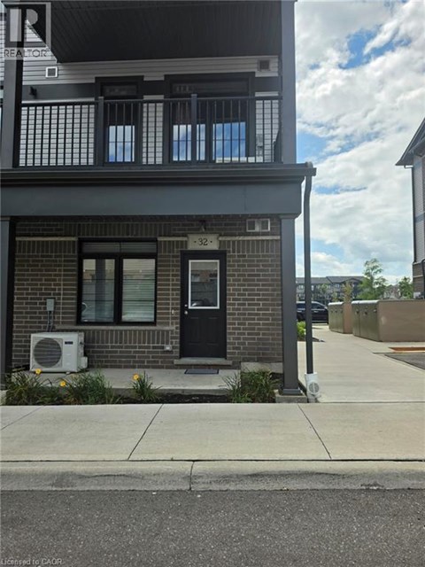 A building with a black door and windows with a sign that says REALTOR.