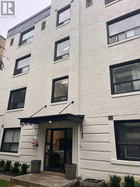 A white building with a black awning and a sign that says REALTOR.