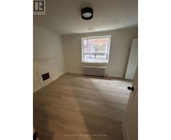 A room with a window and a radiator on the wall.