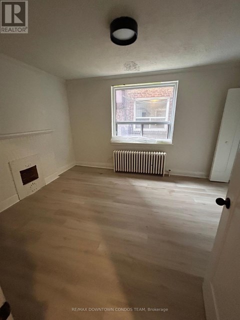 A room with a window and a radiator on the wall.