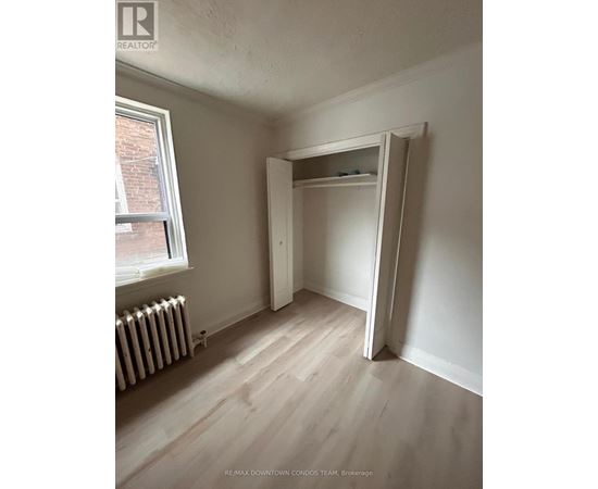 A room with a white wall and a white closet.