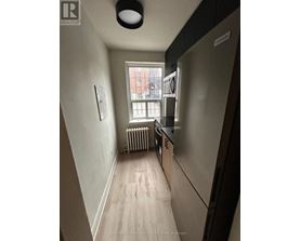 A long hallway with a window and a radiator.