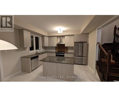 A modern kitchen with a central island and stainless steel appliances.