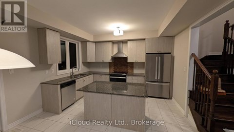 A modern kitchen with a central island and stainless steel appliances.