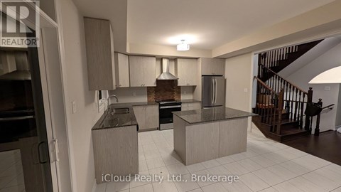 A modern kitchen with a refrigerator, sink, and stove.