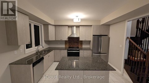A modern kitchen with granite countertops and stainless steel appliances.