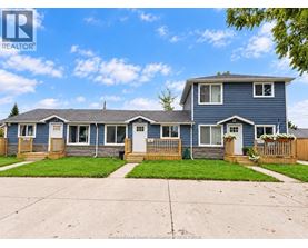 A blue house with a white door and windows is for sale.