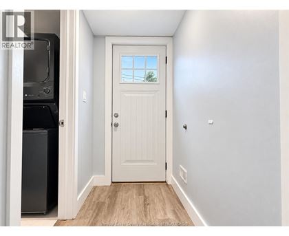 A white door with a window above it in a hallway.