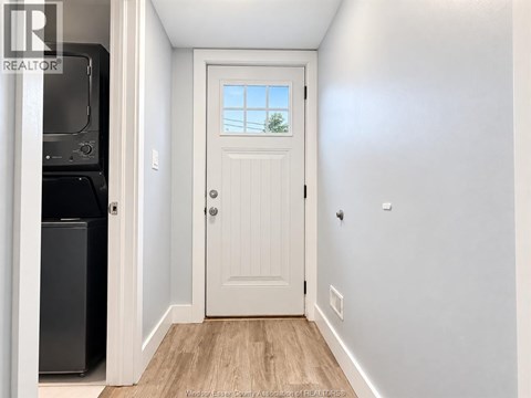 A white door with a window above it in a hallway.