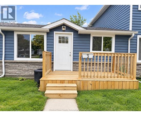 A blue house with a white door and a wooden deck.