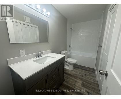 A bathroom with a sink, toilet, and bathtub.
