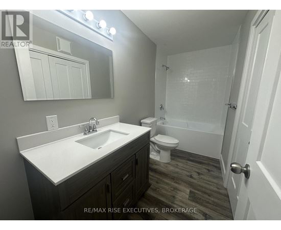 A bathroom with a sink, toilet, and bathtub.