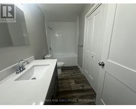 A white sink in a bathroom with a wooden floor.