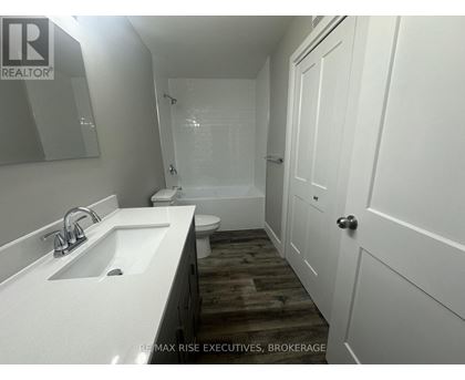 A white sink in a bathroom with a wooden floor.