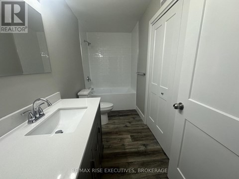 A white sink in a bathroom with a wooden floor.