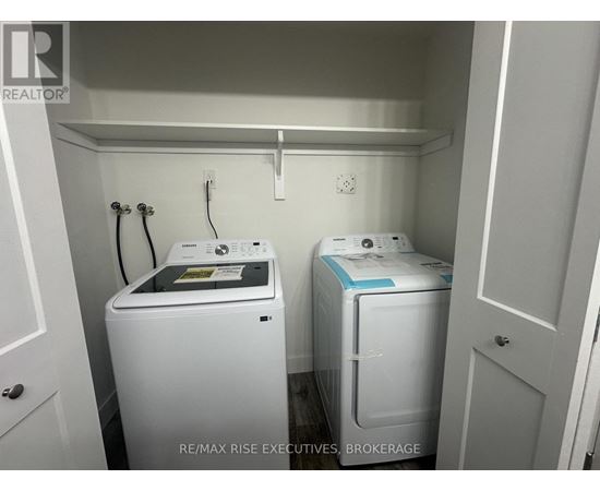 A small laundry room with a washer and dryer.