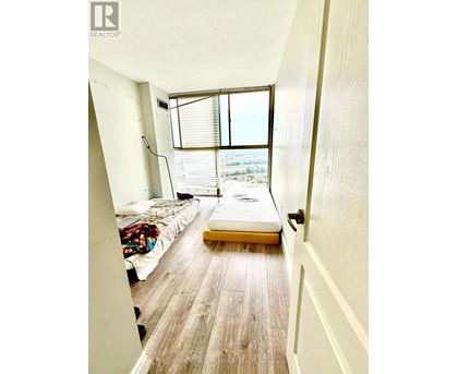 A bedroom with a bed and a window with blinds.