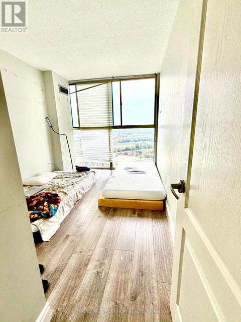 A bedroom with a bed and a window with blinds.