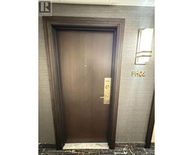 A brown door with a gold handle and a sign that says "PH05" on the wall behind it.