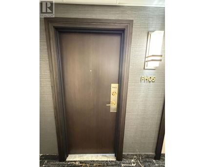 A brown door with a gold handle and a sign that says "PH05" on the wall behind it.