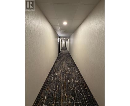 A long hallway with a carpeted floor and white walls.