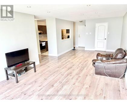 A living room with a brown leather chair and a wooden floor.