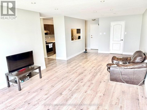 A living room with a brown leather chair and a wooden floor.