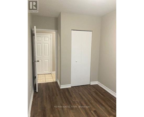 A white door is in a room with a wooden floor.