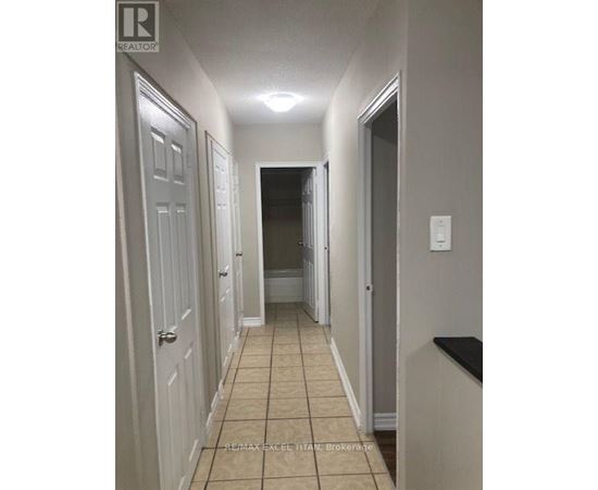 A hallway with white doors and a tiled floor.