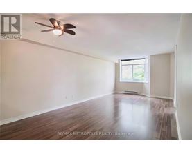 A room with a ceiling fan and wooden flooring.