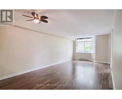 A room with a ceiling fan and wooden flooring.