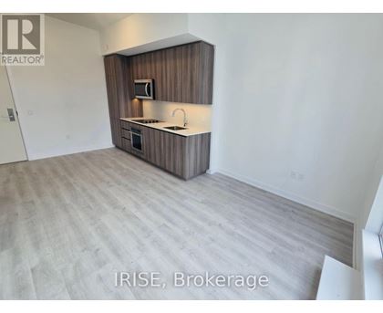 A kitchen with a wooden cabinet and a microwave above the oven.