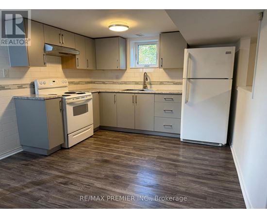 A kitchen with a white fridge, stove and cabinets.