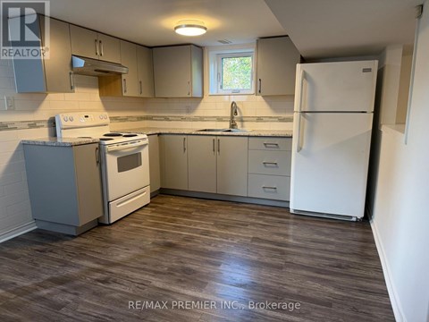 A kitchen with a white fridge, stove and cabinets.