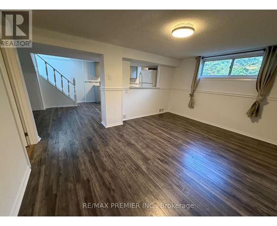 A room with wooden flooring and a window with curtains.