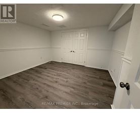 A room with a white door and a wooden floor.