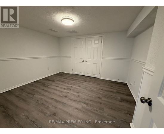 A room with a white door and a wooden floor.