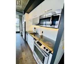 A modern kitchen with white cabinets and stainless steel appliances.