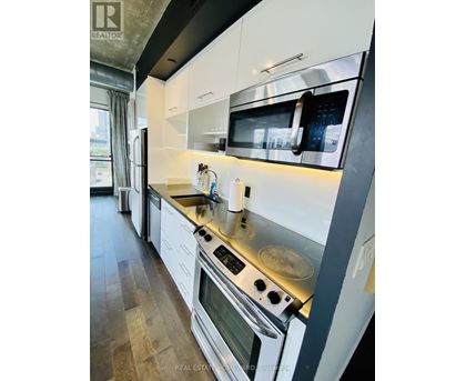 A modern kitchen with white cabinets and stainless steel appliances.