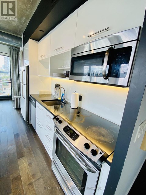 A modern kitchen with white cabinets and stainless steel appliances.