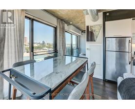 A modern kitchen with a glass table and a view of the city.