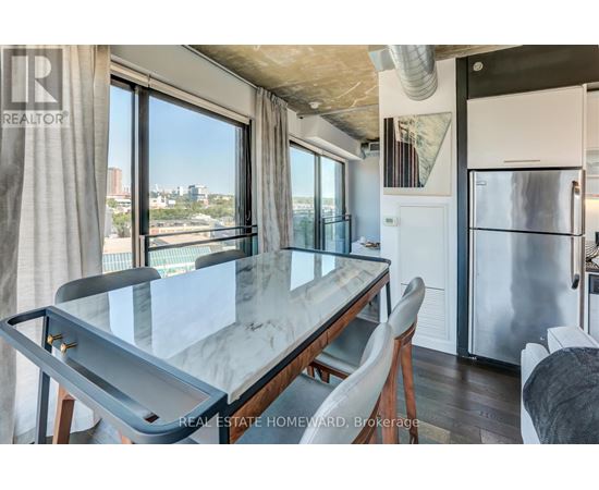 A modern kitchen with a glass table and a view of the city.