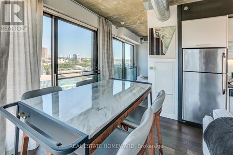 A modern kitchen with a glass table and a view of the city.