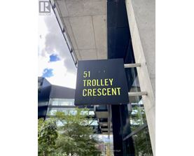 A sign that says Trolley Crescent in yellow on a black background.