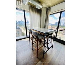 A dining room with a table and chairs and a view of the city.